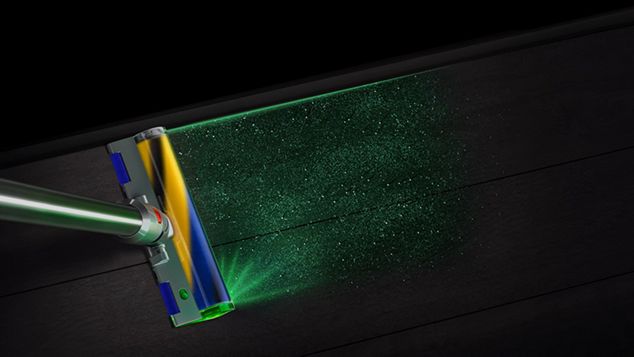 Dyson V15 Detect Absolute Fluffy Optic cleaner head lighting up all the dirt on the floor.